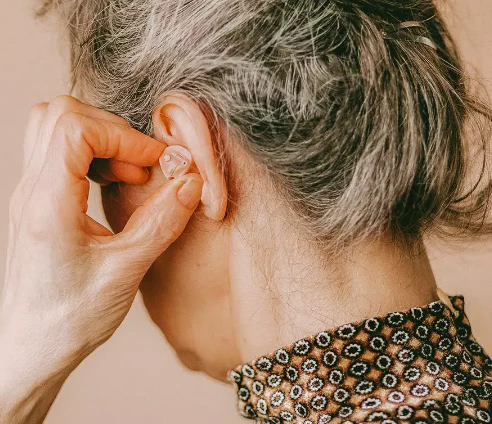 A hearing-impaired elderly man with a hearing aid